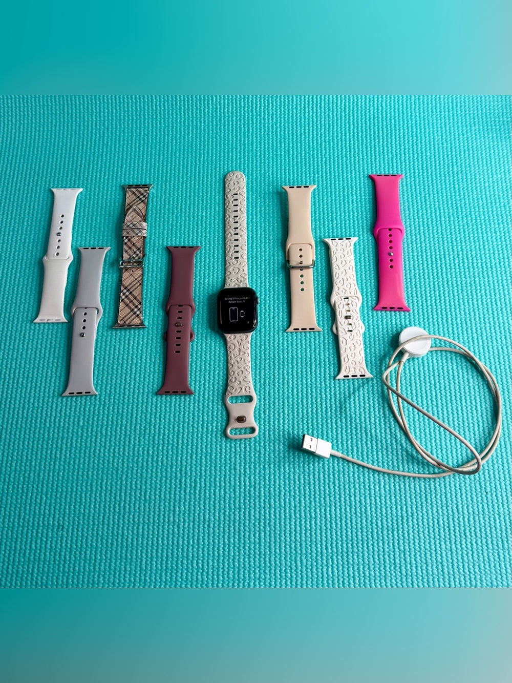Apple Watch with Beige Patterned Sport Band and Assorted Color Bands